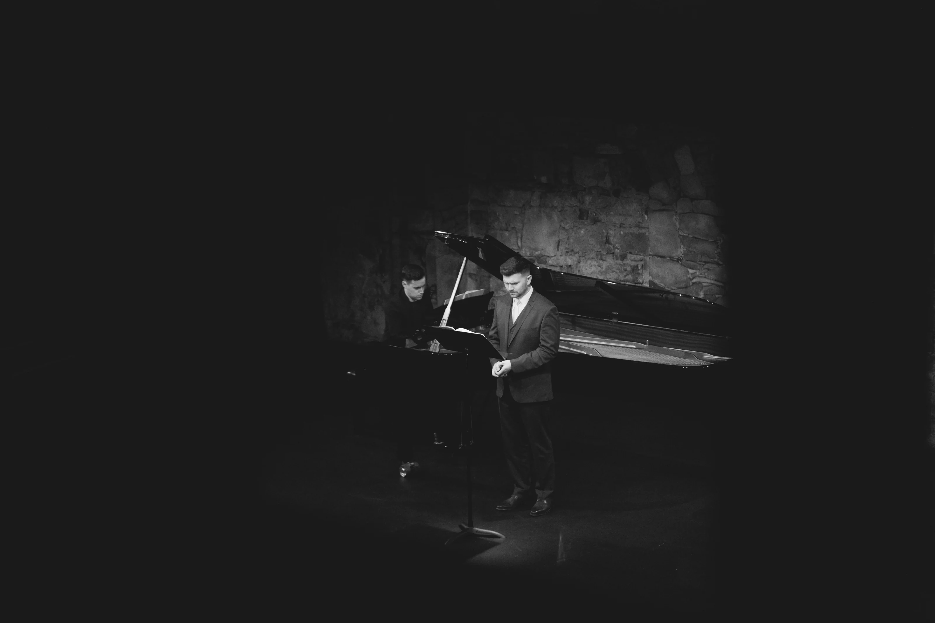 Andrew Gavin performing beside a grand piano