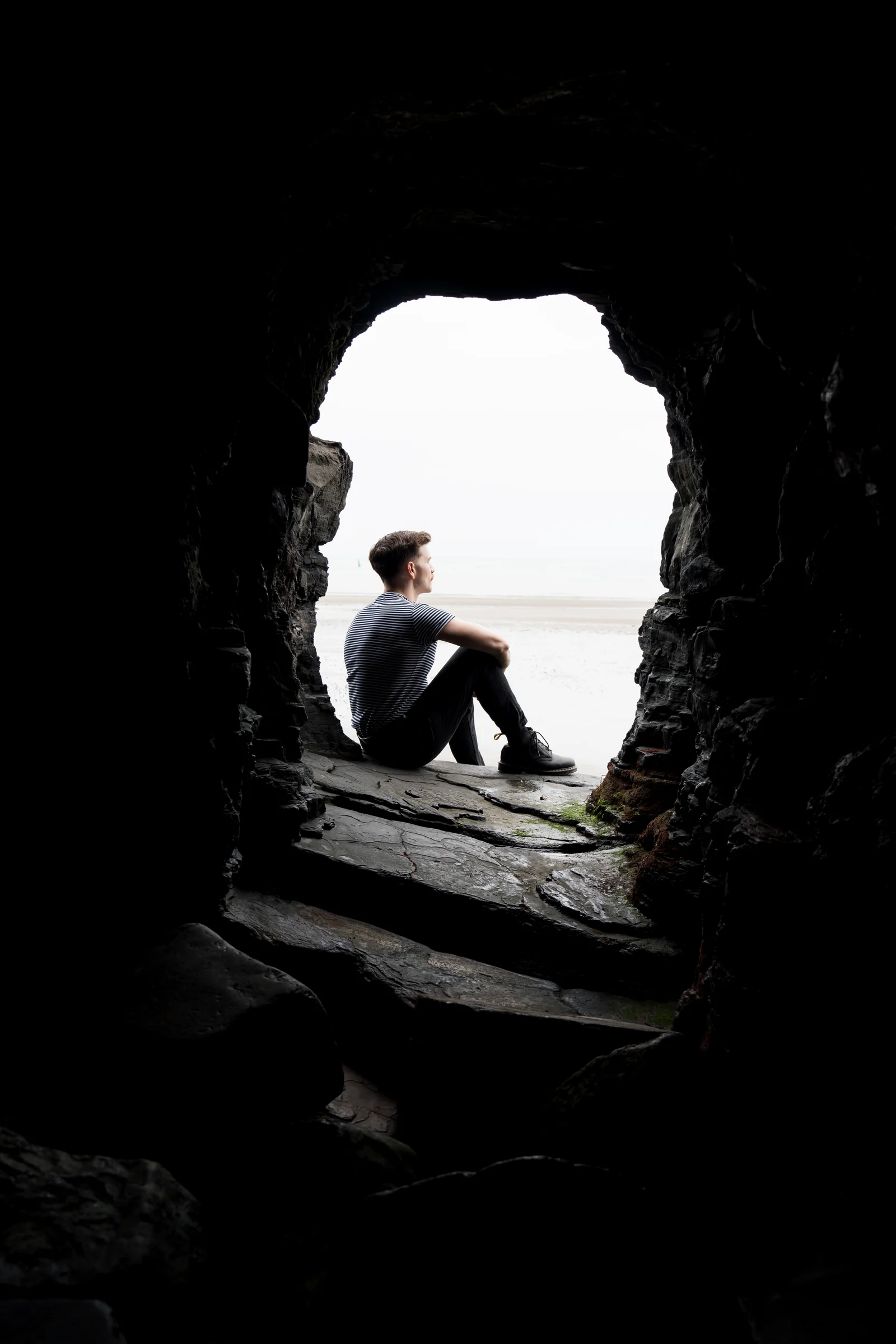 Andrew Gavin seated in the mouth of a sea cave