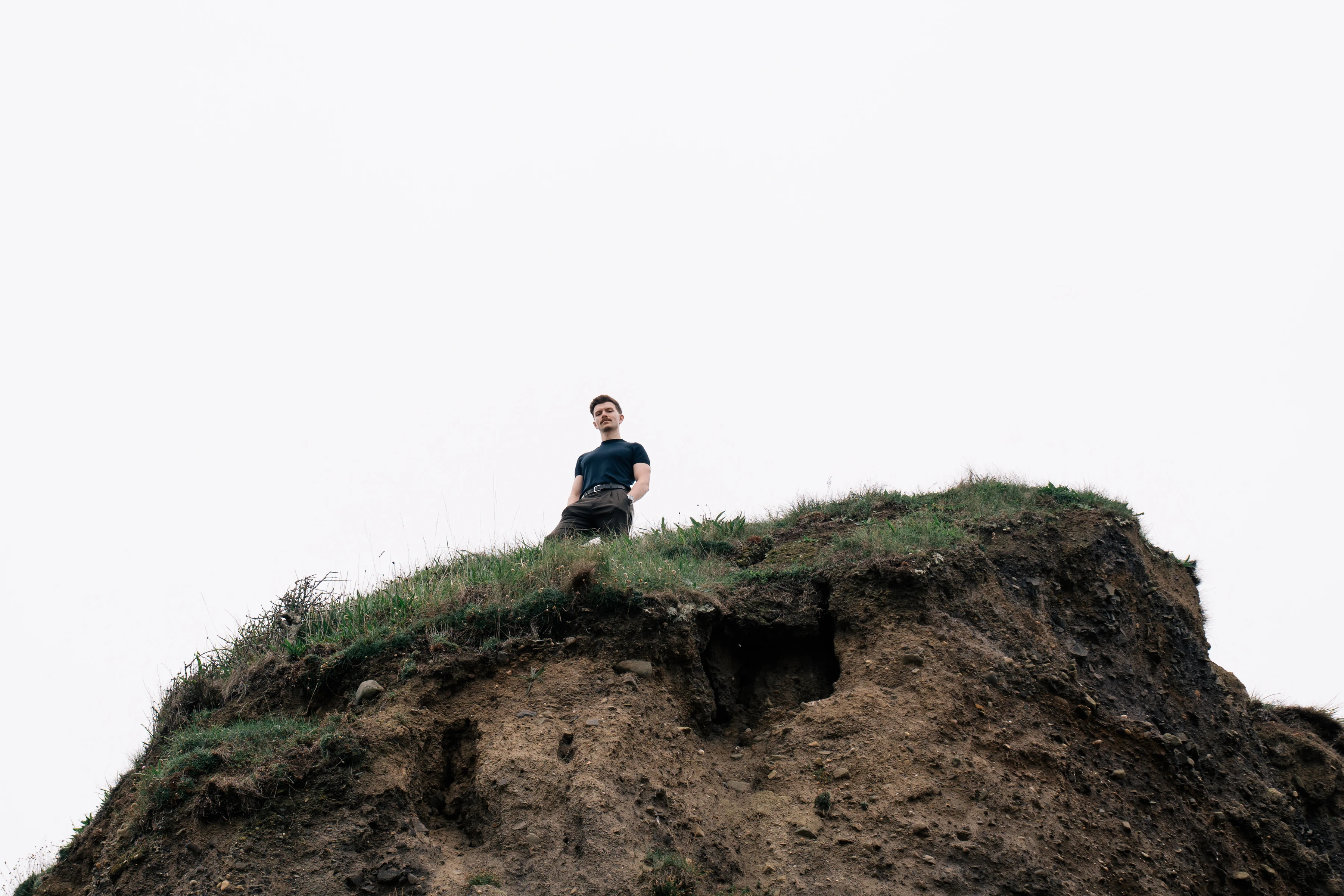 Andrew Gavin standing on a dramatic grassy cliff