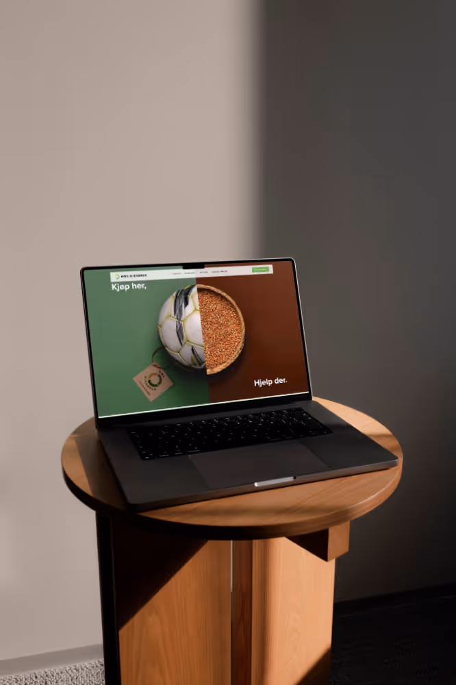 Bærbar datamaskin med nettside som viser en fotball delt i to; halvparten av ballen og halvparten av korn.