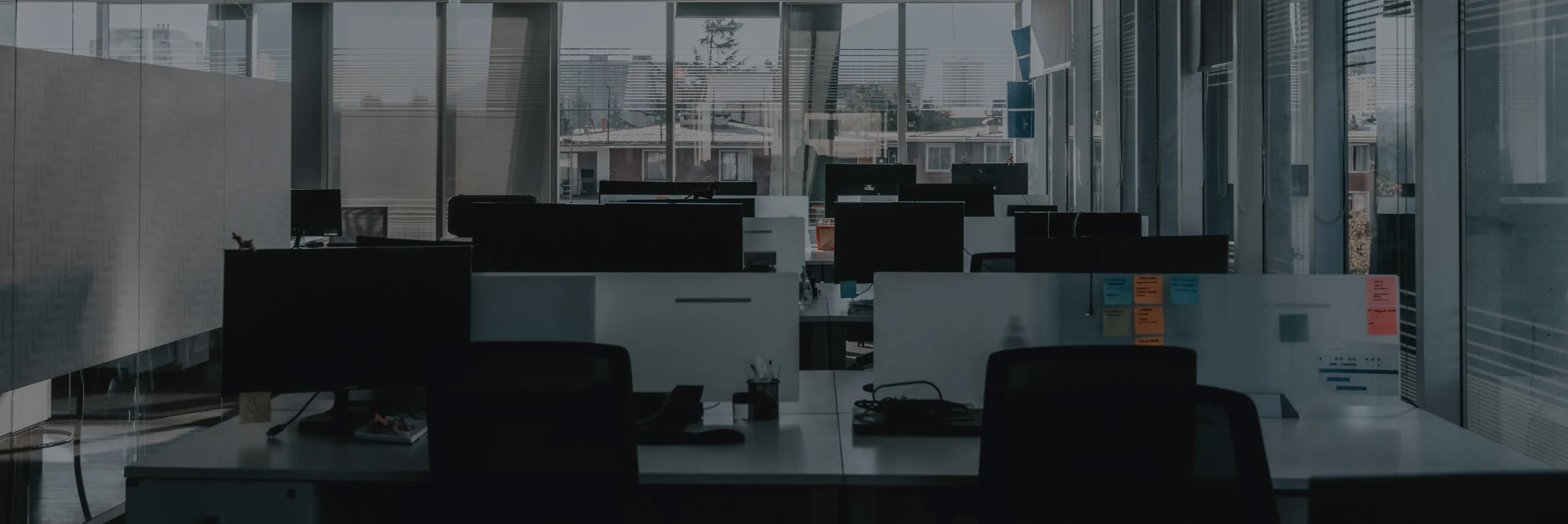 Modern empty office space with computers and glass walls, representing corporate environment