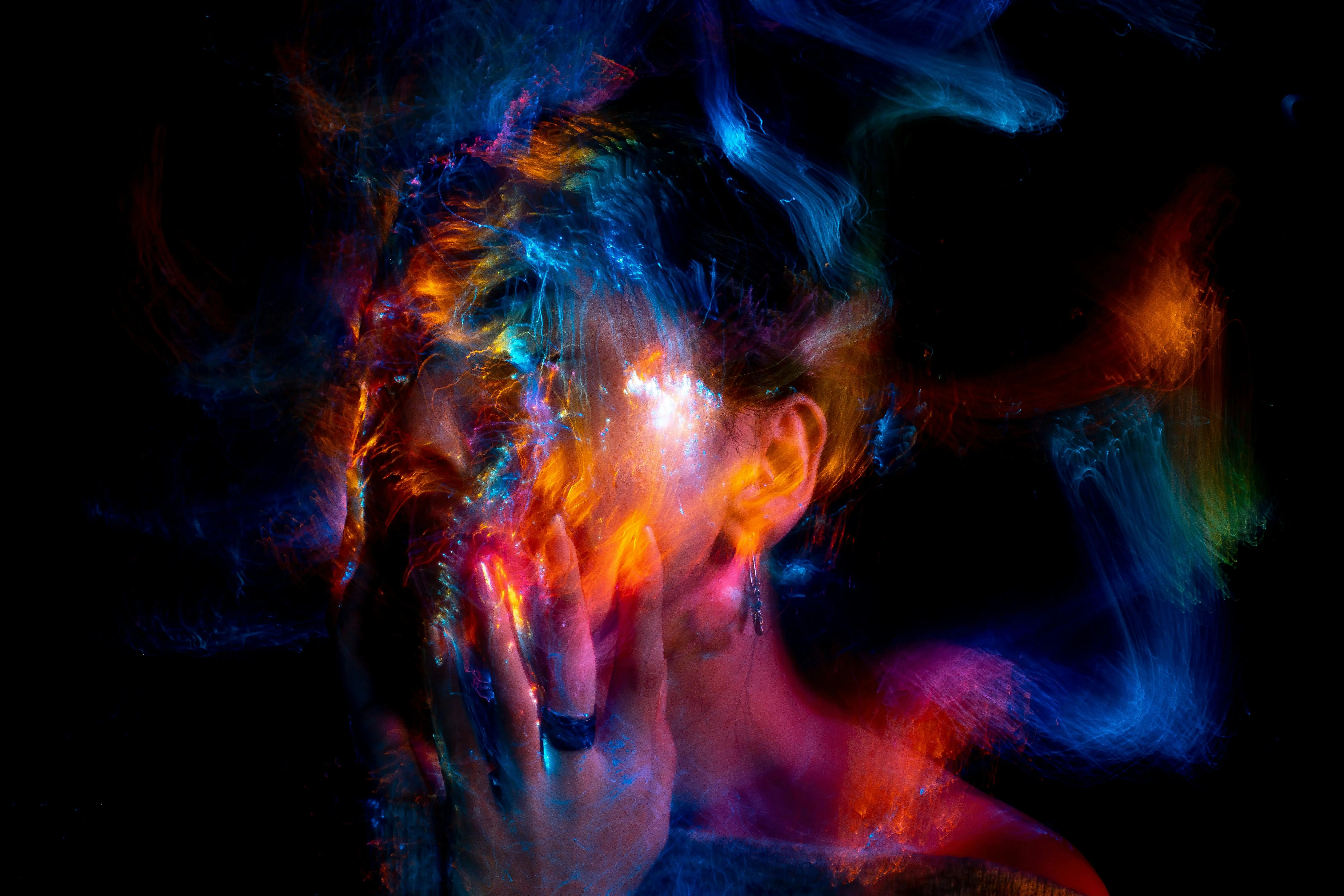 A woman's face covered in colored smoke.