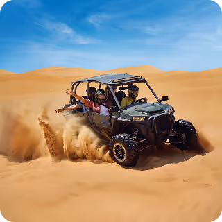 Two people driving an off-road dune buggy kicking up sand in a desert with smooth sand dunes and blue sky.