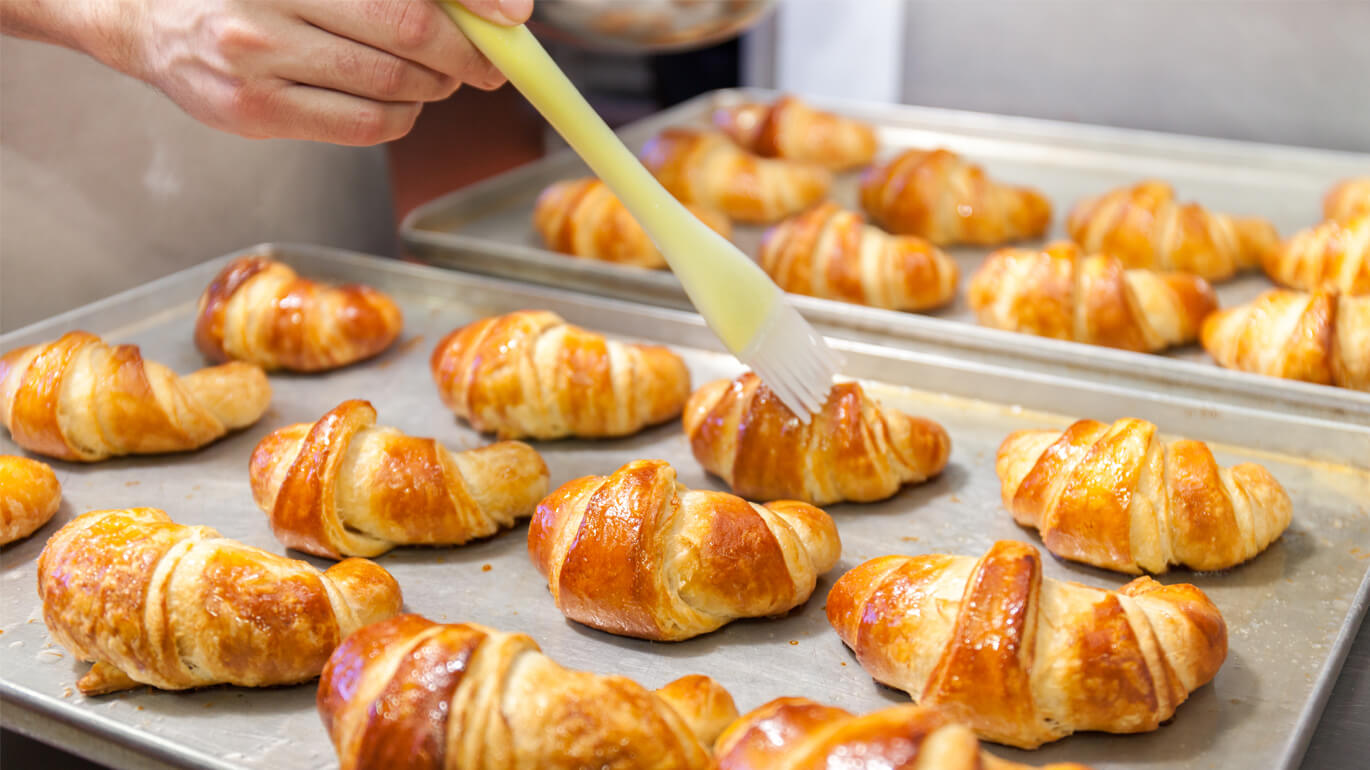 Several croissants spread with butter