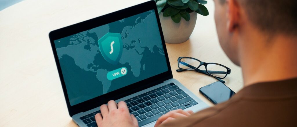 A photograph of a man working on his laptop