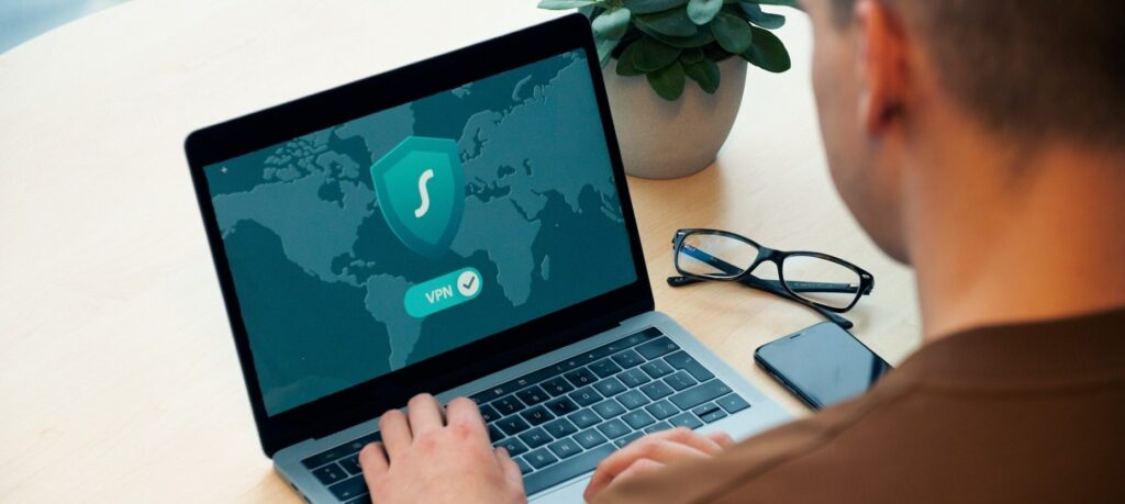 A photograph of a man working on a laptop.