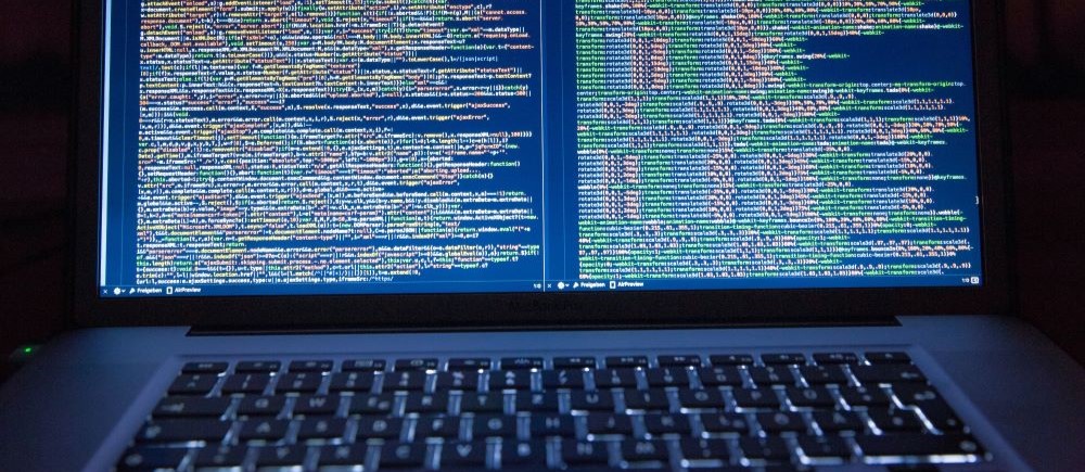 A photo of a laptop with coding on the screen.