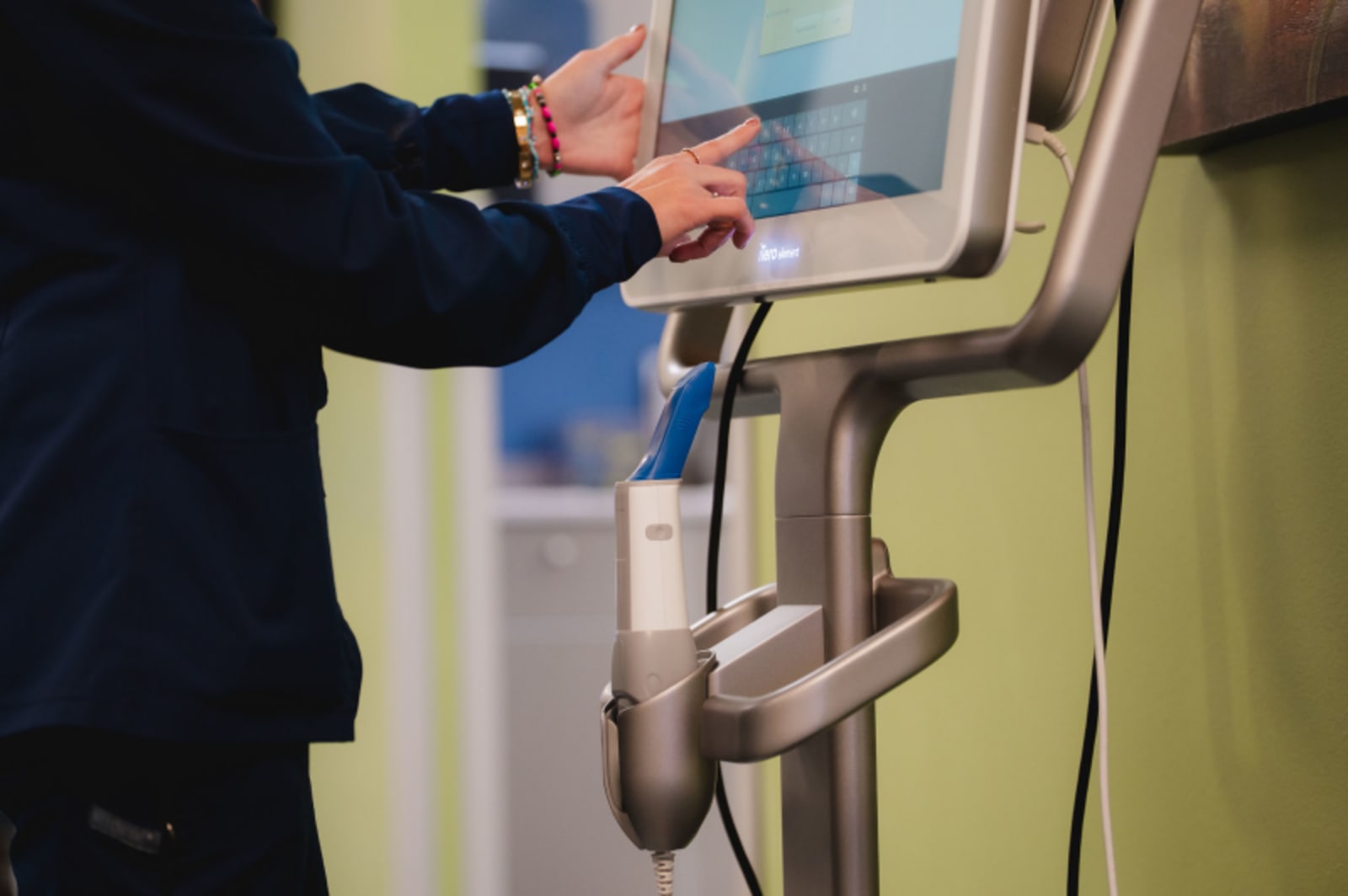 Dentist using digital scanner on patient's teeth during examination