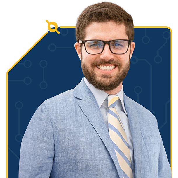 Smiling man with glasses wearing a light blue suit and striped tie against a blue background with yellow circuit-like accents.