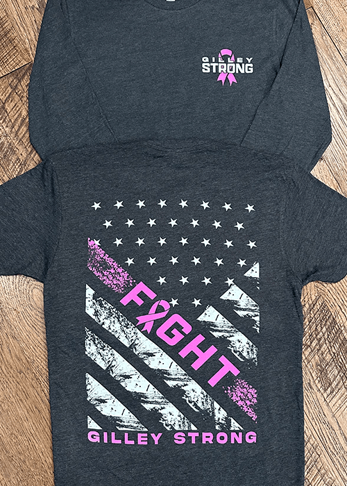 Dark gray shirt with 'Gilley Strong' and a pink ribbon on the front and a distressed American flag design on the back with pink ribbon and the word 'FIGHT' in pink letters.