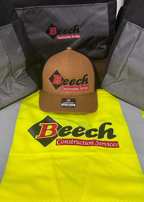 Brown hat, yellow safety vest, and black bags featuring the Beech Construction Services logo.