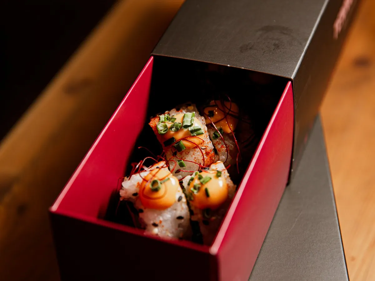 Geöffnete Tenno Sushi Box mit flambiertem Lachs-Sushi.