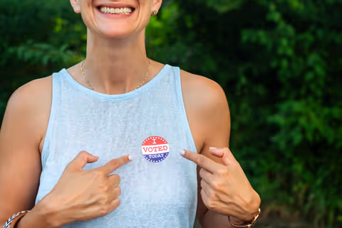 A lady displaying her I Voted sticker