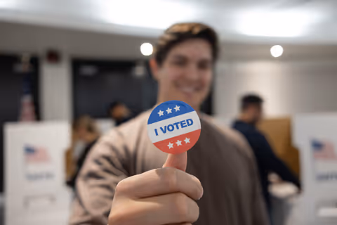 A young man displaying his I Voted sticker