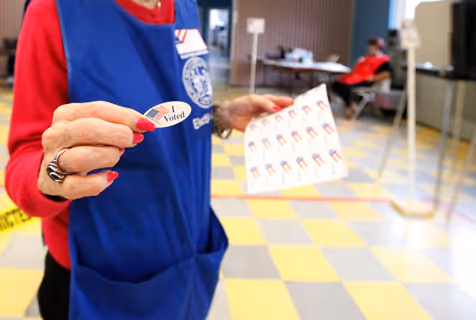 An electioneer handing out I Voted sticker