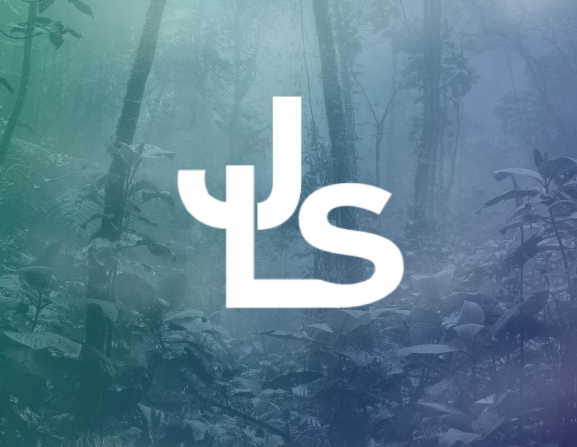 White stylized JLS logo over a misty forest background with green and blue gradient overlay.