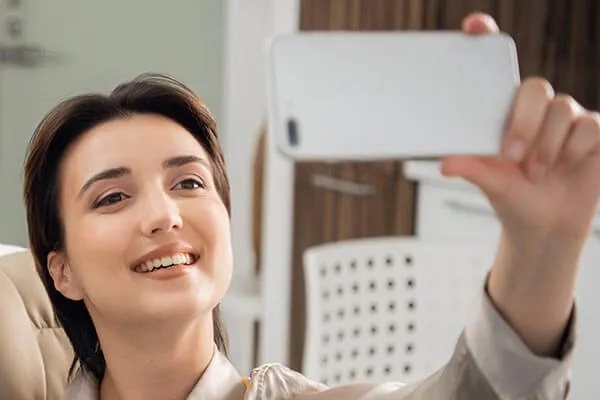 A woman taking a picture with her cell phone.