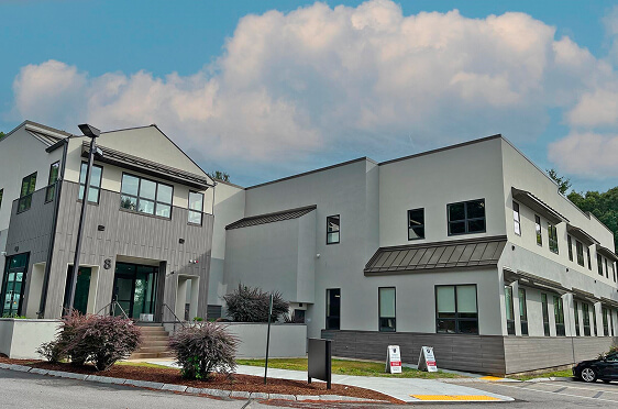 Rocky Portsmouth, New Hampshire coastline with distant lighthouse, representing Cornerstone Financial Planning’s Portsmouth office location.