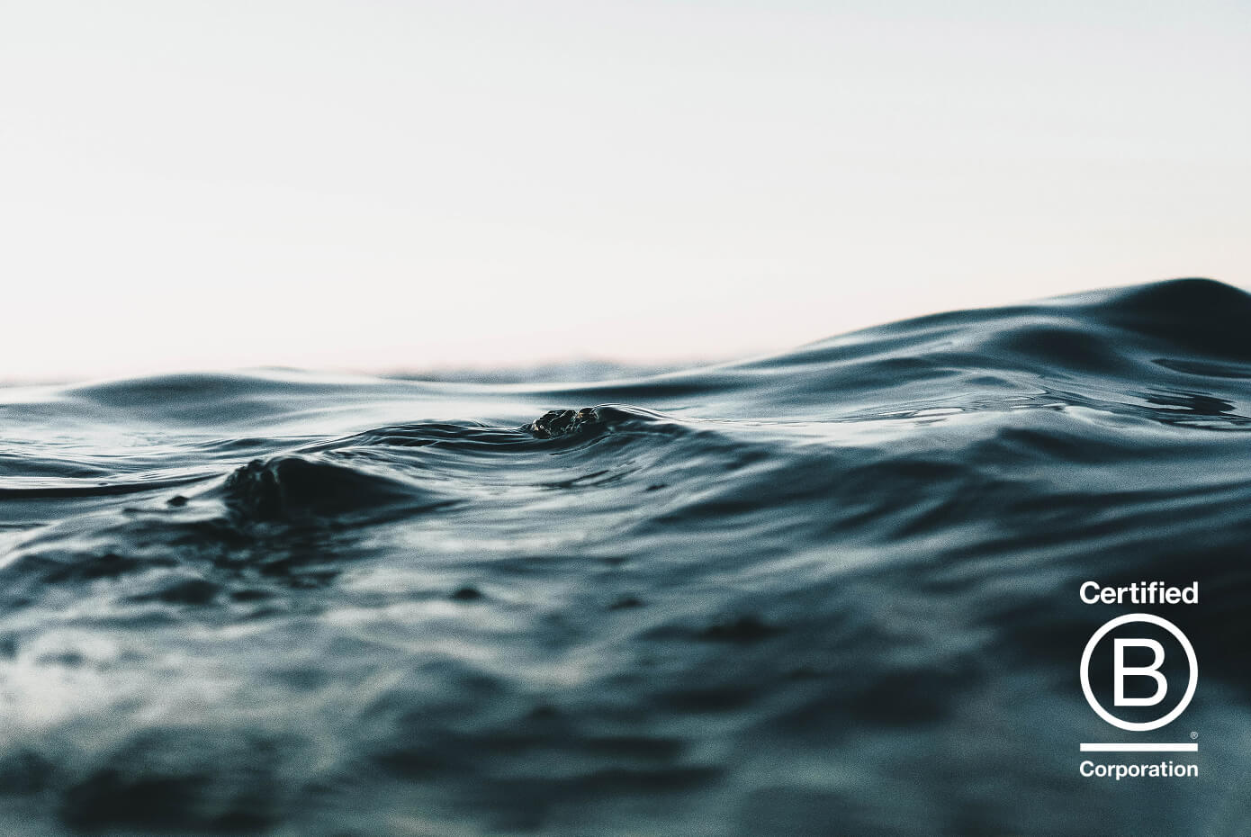 Ocean waves with Certified B Corporation™ logo, highlighting Cornerstone’s commitment to responsible, values-driven financial planning.