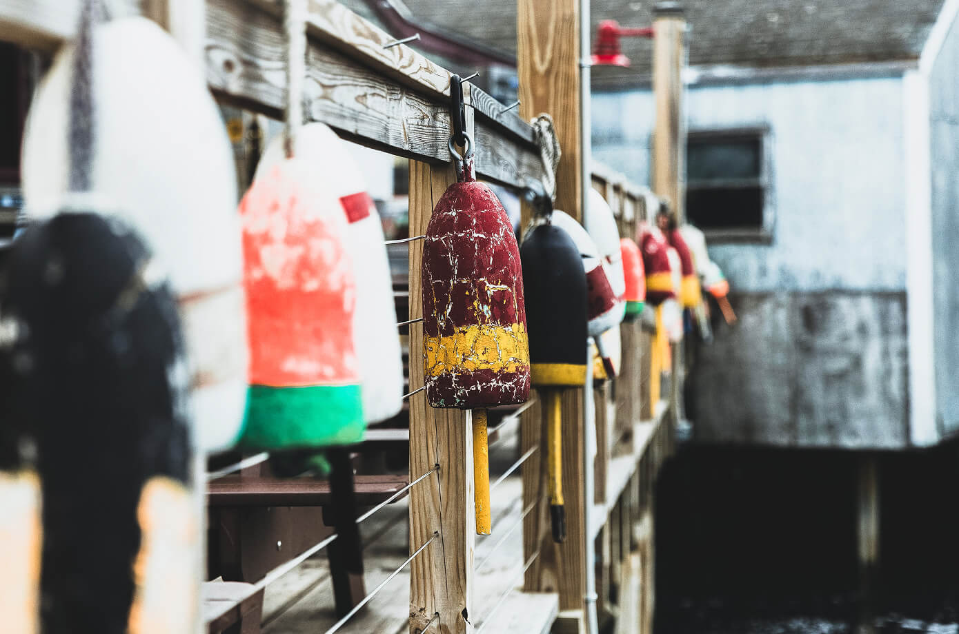 Colorful lobster buoys on a Maine dock, reflecting Cornerstone’s coastal community roots and local financial support.