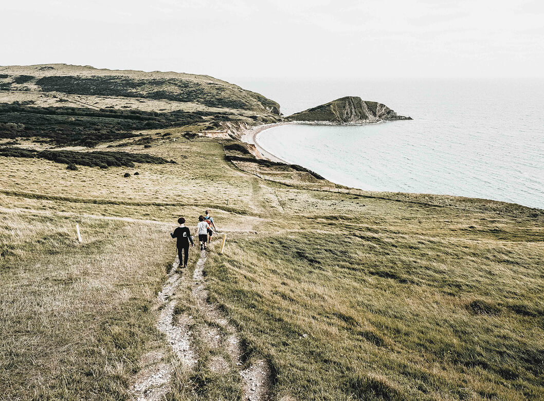 Group hiking along a coastal trail, symbolizing teamwork, community, and forward-looking financial strategies.