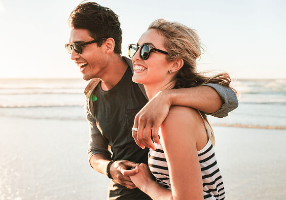 Young couple walking on the beach, representing financial freedom and wealth management guidance from Cornerstone Financial Planning.