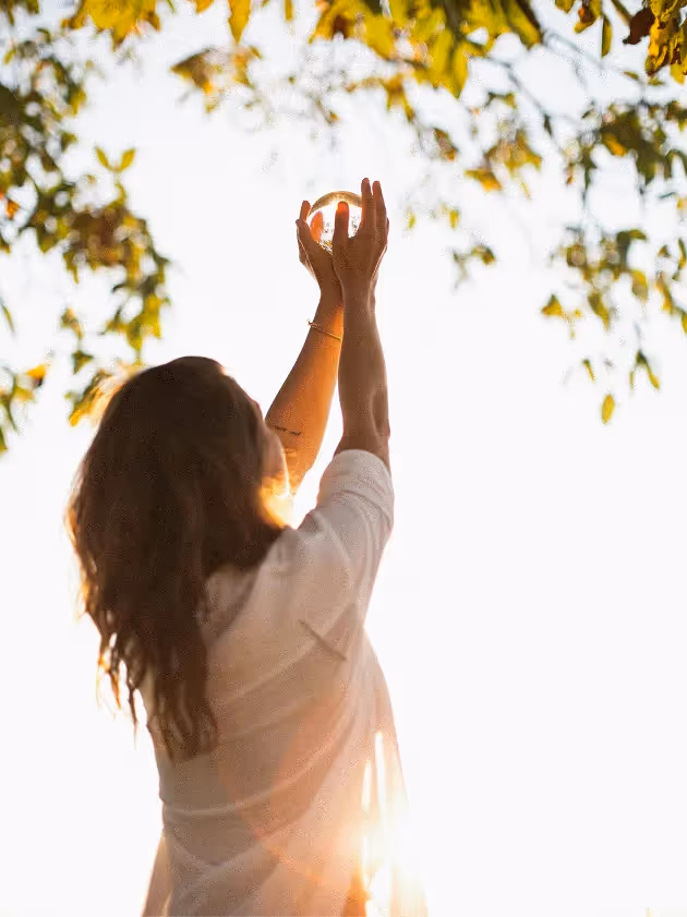 Male doctor with stethoscope smiling and reassuring a seated female patient in a clinic room.