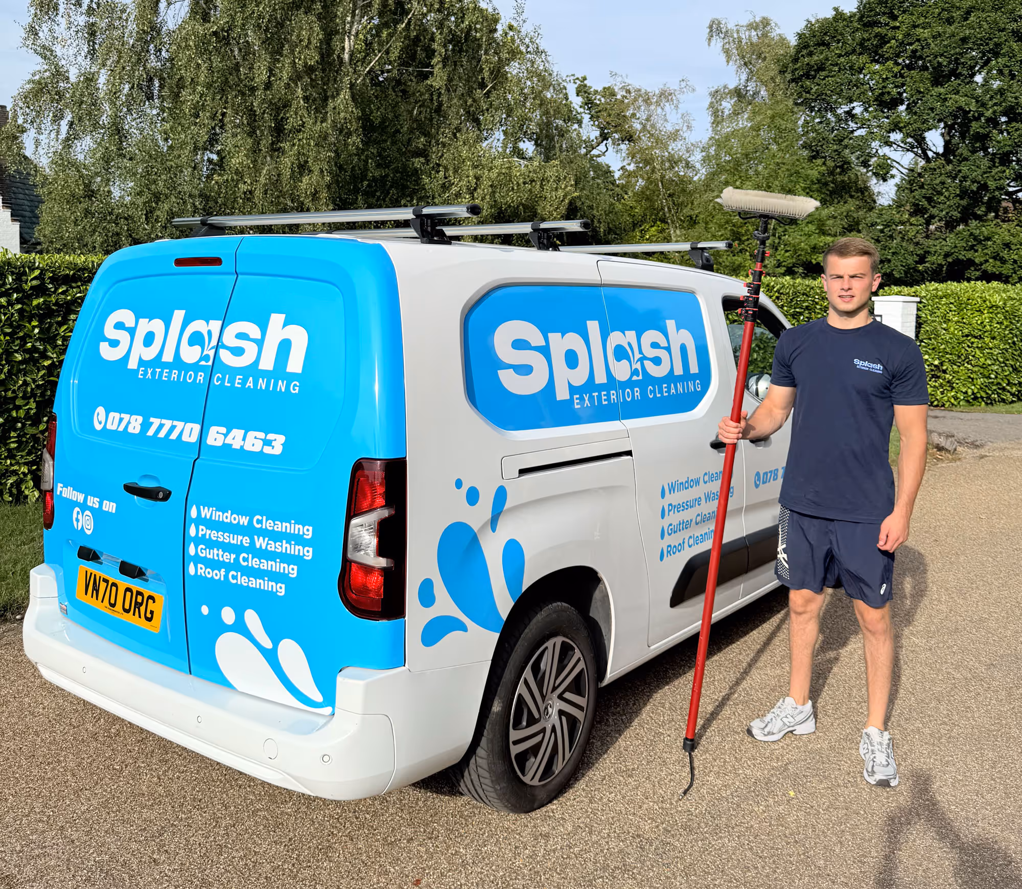 Lewis stood next to Splash Exterior Cleaning van holding exterior cleaning equipment.