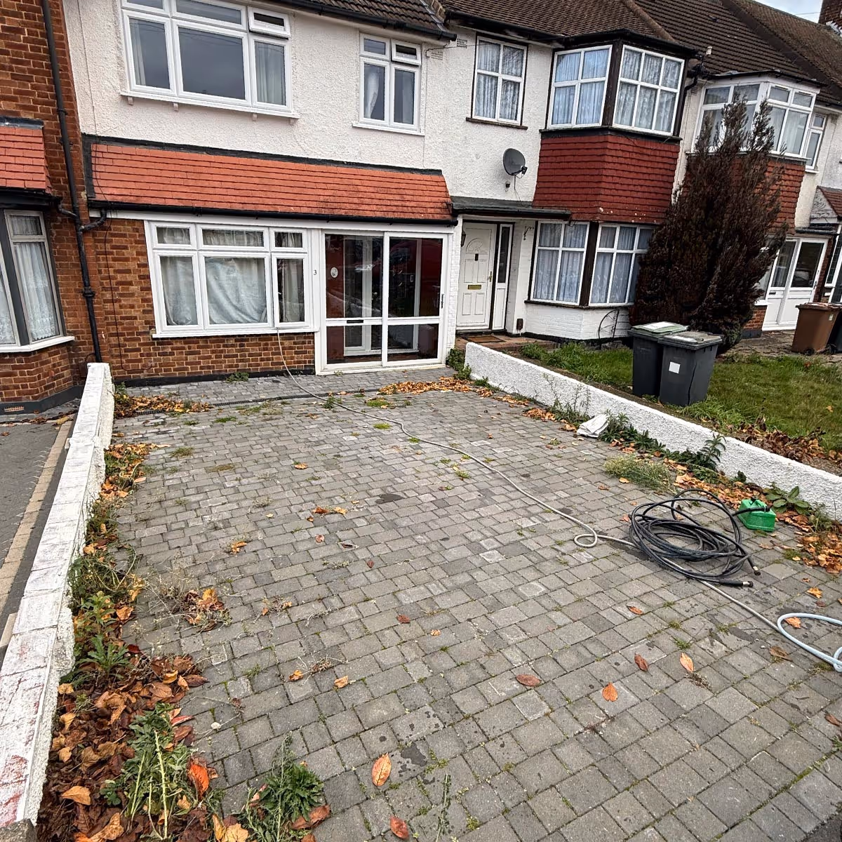 A London home driveway that is discoloured and has leaves and debris on it.