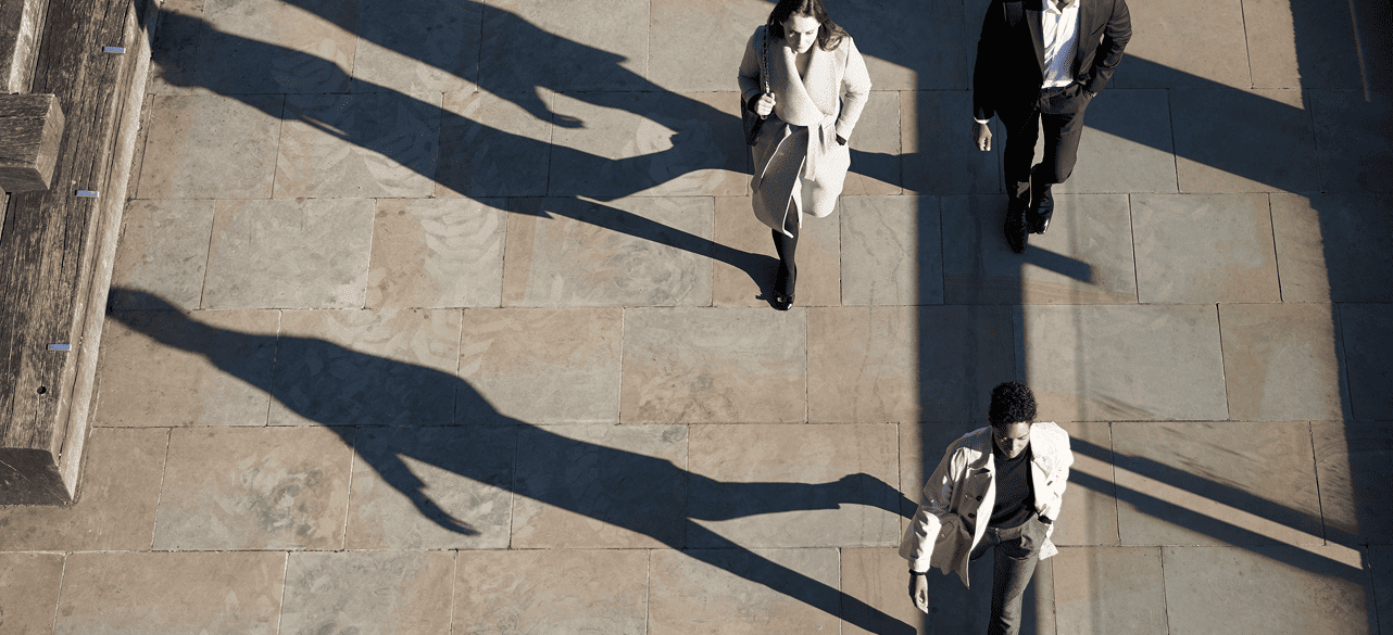 Woman and man in professional attire standing at a window, talking