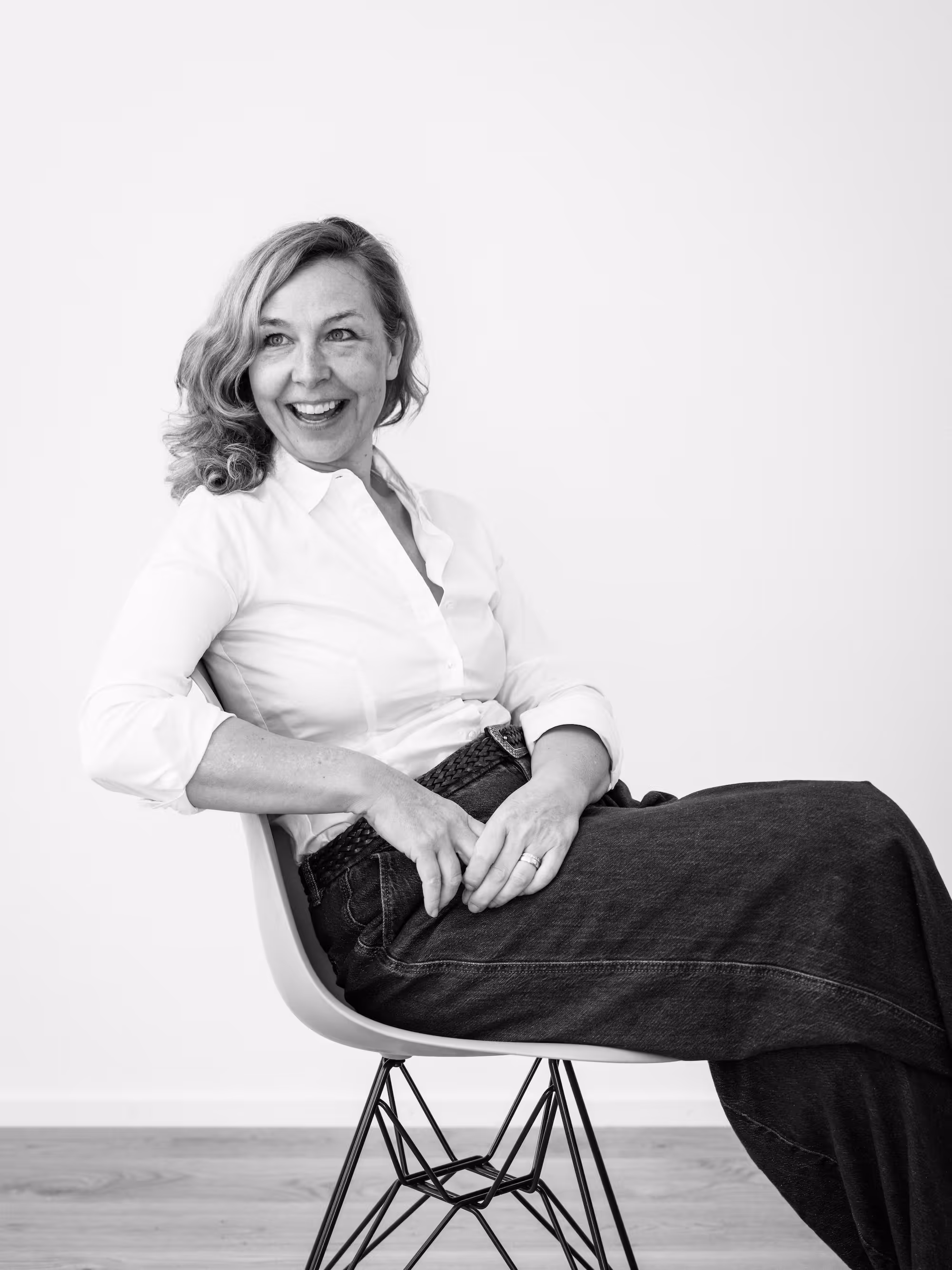 Katja Saenze Porträt-Grafik-Art, Frau sitzt lächelnd auf Stuhl