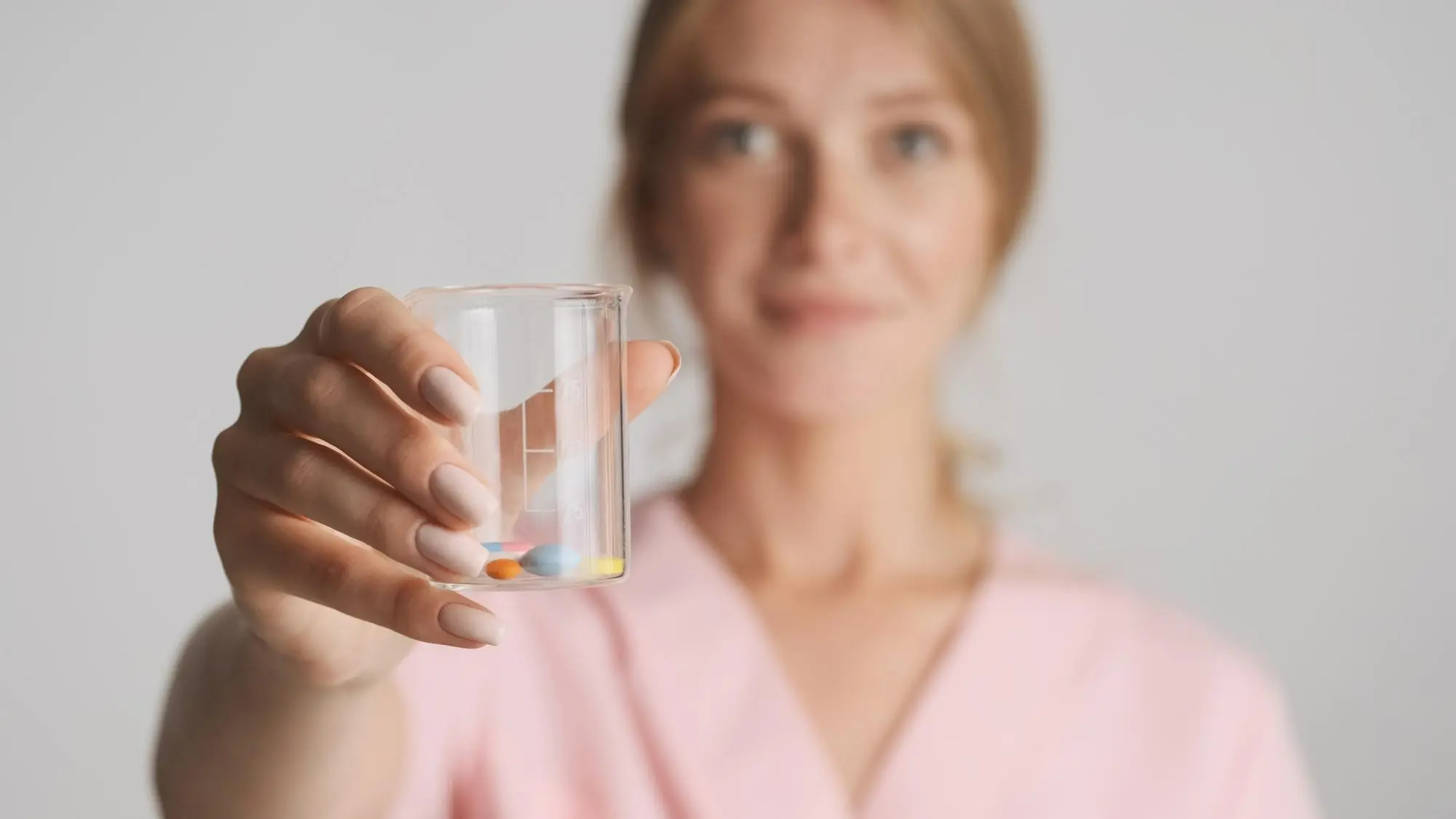 Woman holding medication prescribed as part of a medication management plan for addiction treatment