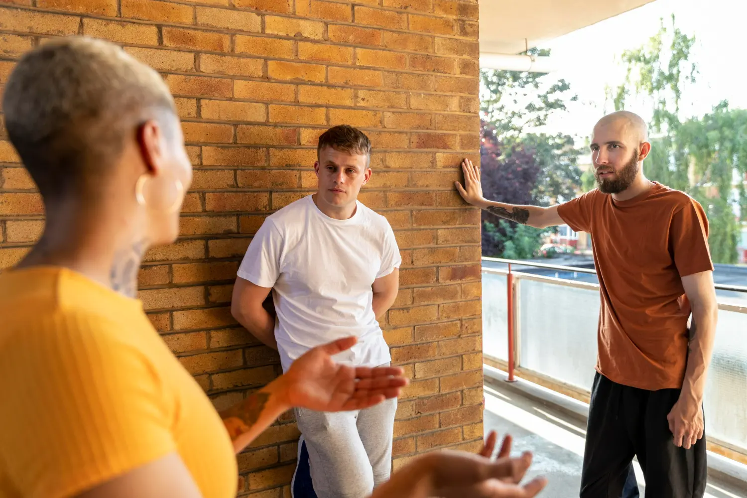 Three people talking together outside, representing peer connection and support in recovery