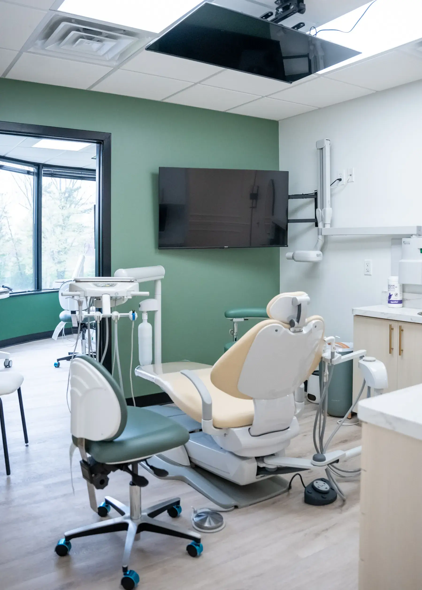 A dental examination room with a dentist chair and medical equipment.