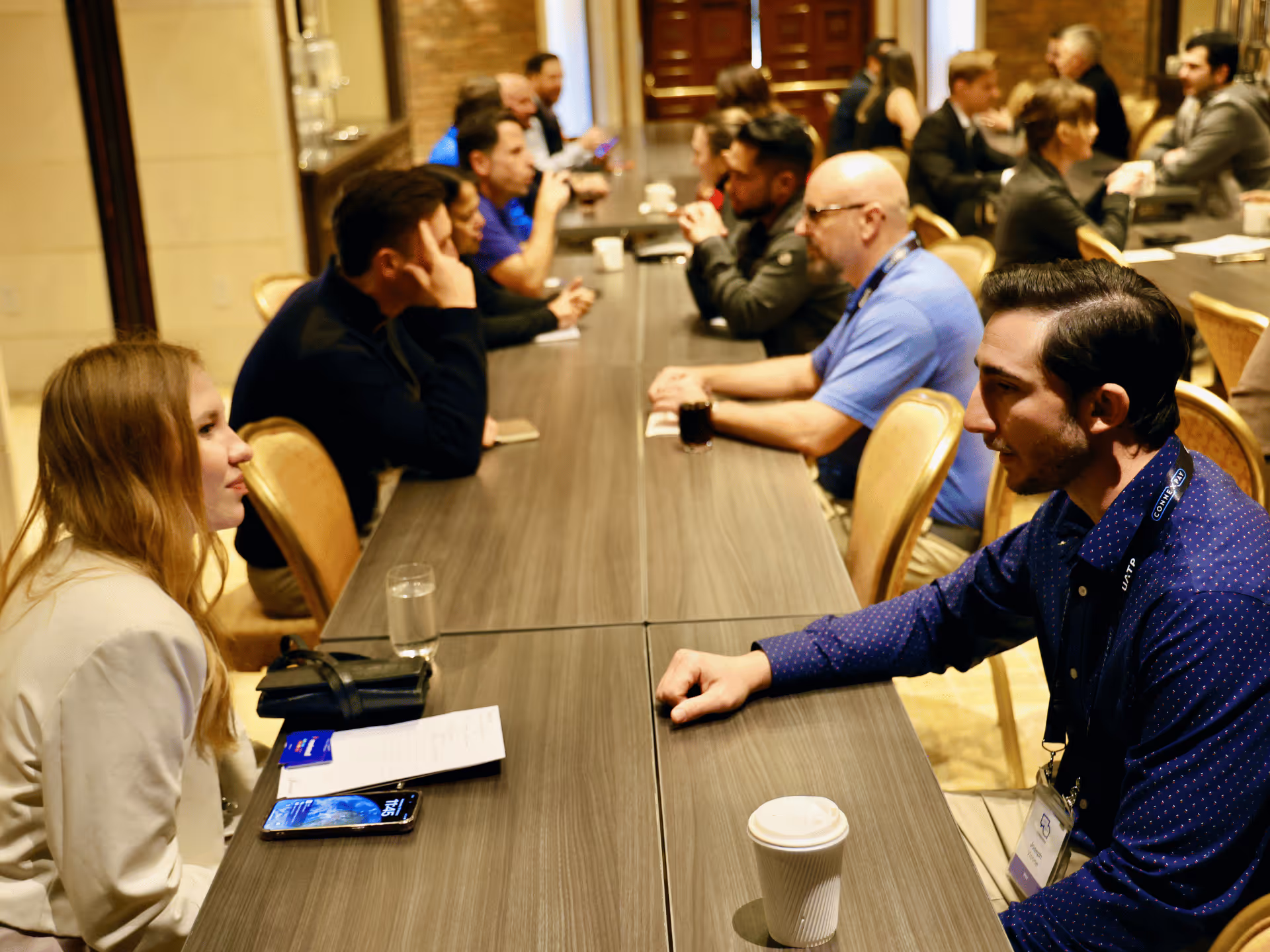 Group of people posing with three luxury sports cars in red, yellow, and gray, with palm trees and a marina in the background.
