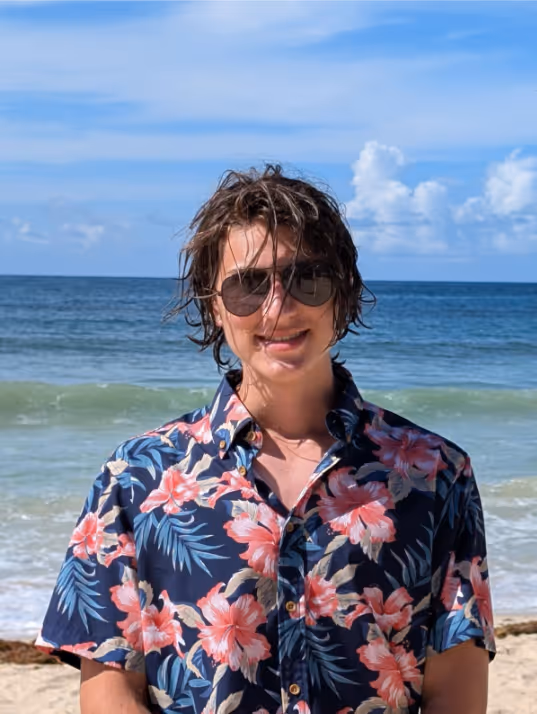 Image joyeuse d'un web developpeur souriant sur le bord de la mer