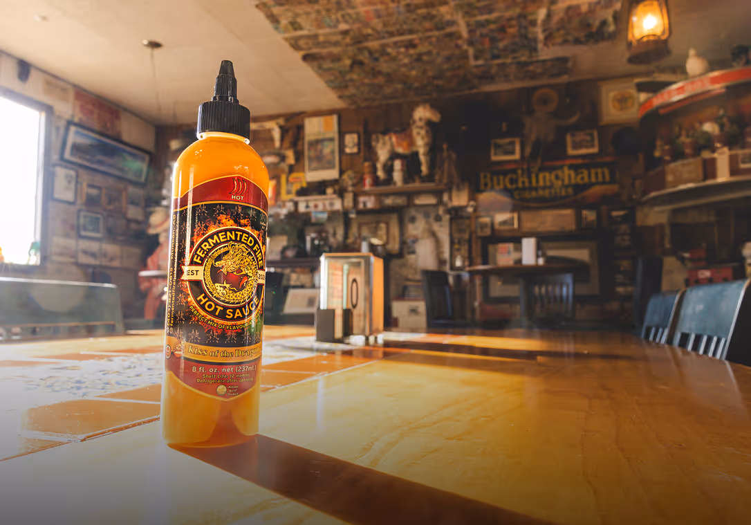 Fermented Fire Hot Sauce bottle on a table in a restaurant.