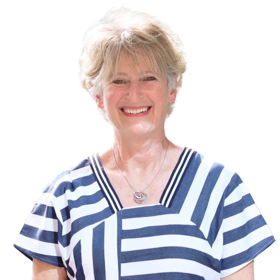 Smiling older woman with short blond hair wearing a white and navy striped top and a silver necklace.