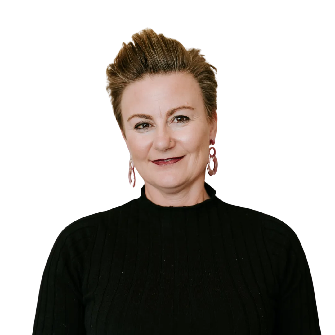 Smiling woman with short styled hair wearing a black ribbed sweater and pink hoop earrings.