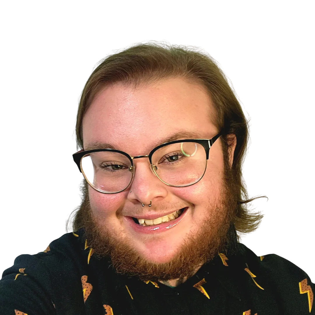 Smiling person with glasses, a beard, and a septum piercing wearing a black shirt with lightning bolt patterns.