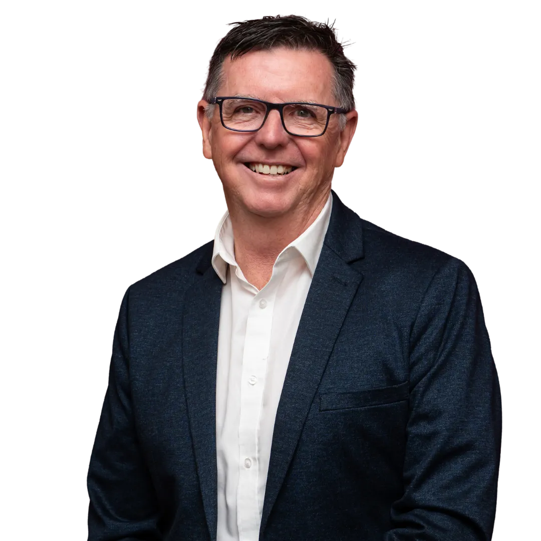 Smiling middle-aged man wearing glasses, a white shirt, and a dark blazer.