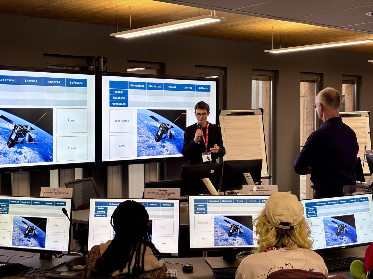 image of engineers working on satellite components [team]