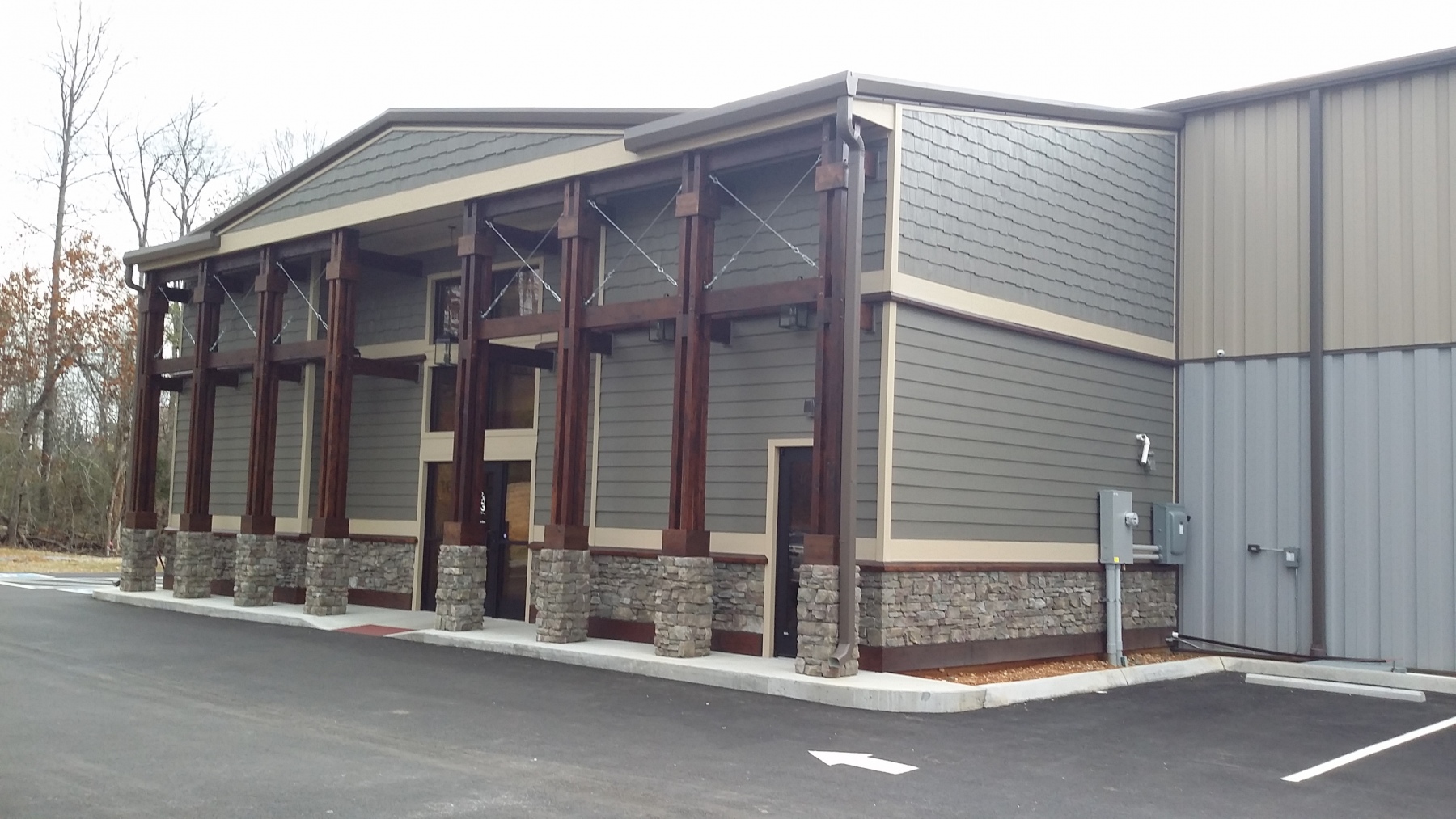 A specialized commercial athletic facility designed for high-performance training, featuring a rugged mountain-modern exterior and a sprawling, functional interior.