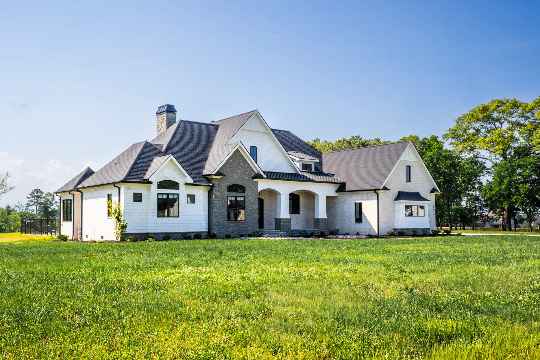 A striking custom home that seamlessly merges classic light-brick masonry with contemporary architectural lines and clean, sophisticated interior spaces.