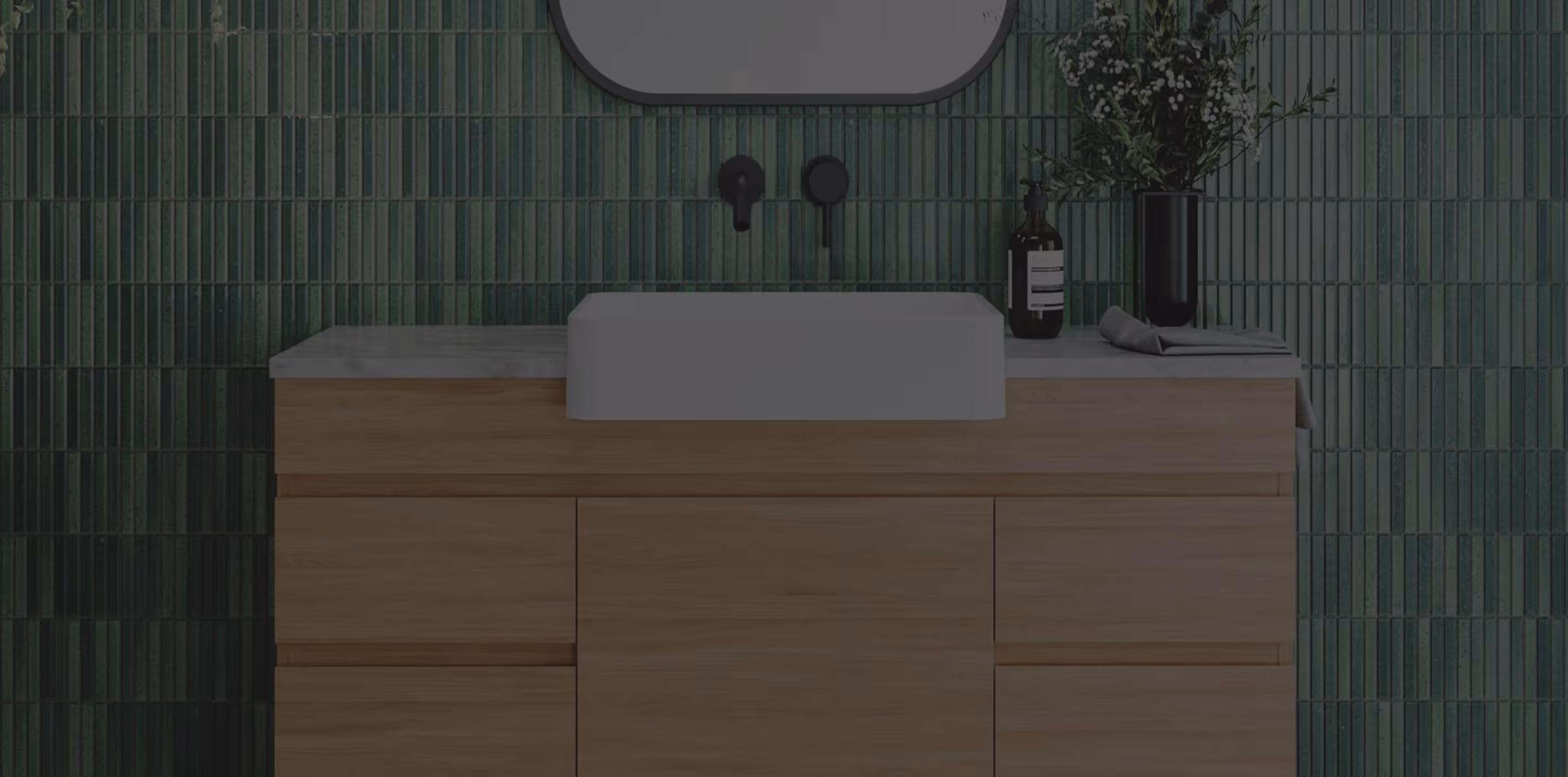 Modern bathroom vanity with wooden drawers, white rectangular sink, black fixtures, and green tiled wall.