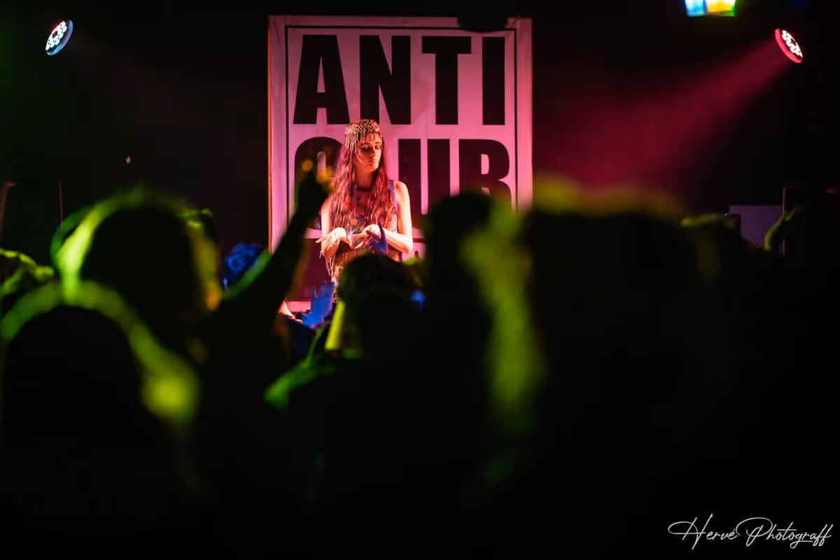 DJ Momo sur scène au Cabaret du Nouvel An du Cirque Électrique, devant une foule animée.