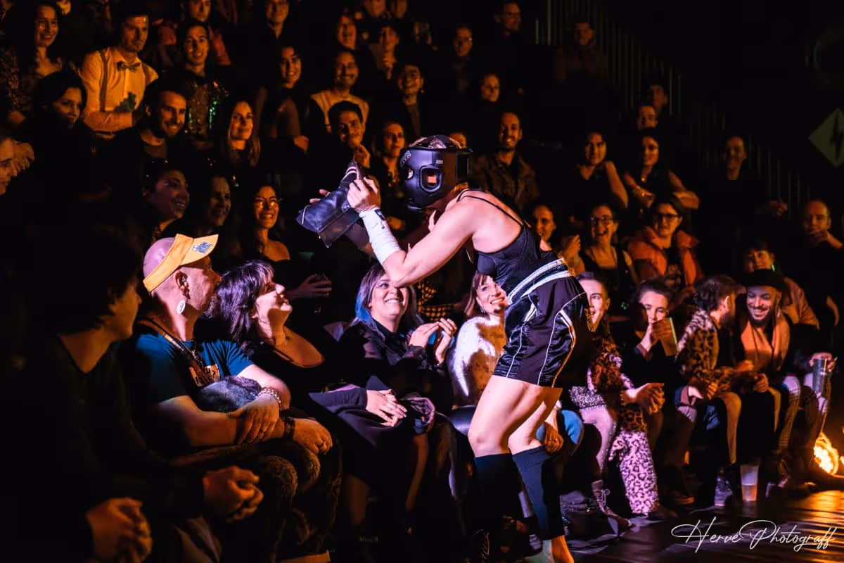 Artiste masqué en tenue de boxeur interagissant avec le public pendant le spectacle.