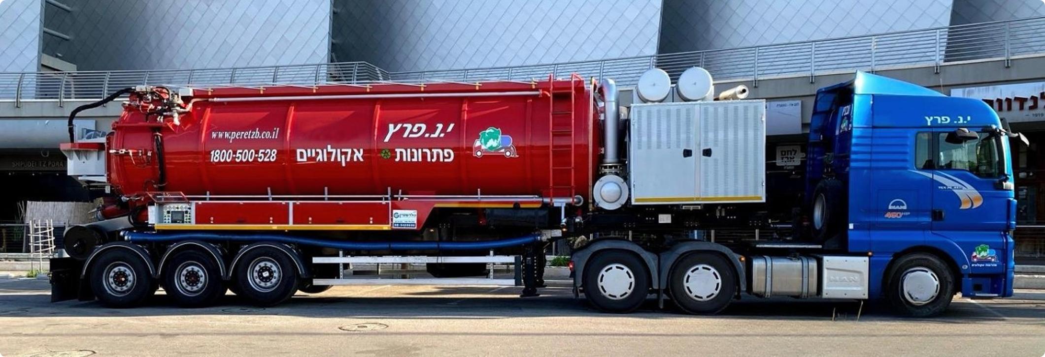 משאית ביובית אדומה וכחולה של י.נ פרץ עומדת בחנה