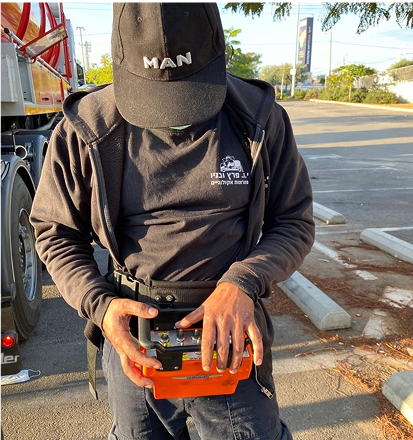 עובד עם כובע מבצע עבודת שאיבת ביוב בשטח