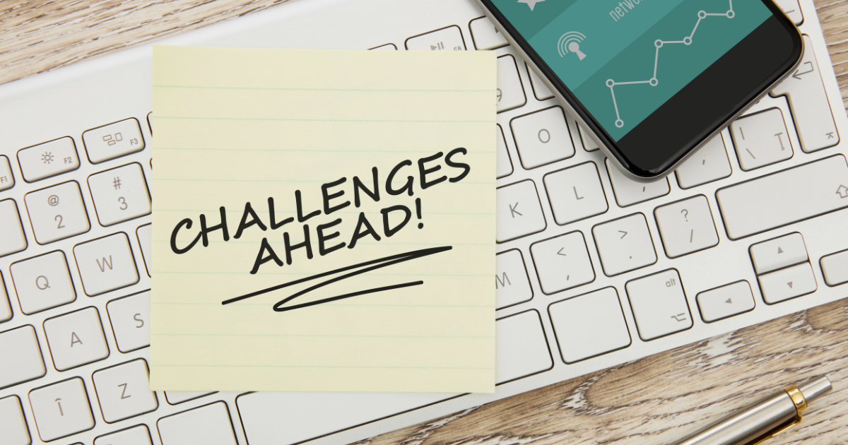 Sticky note reading “Challenges Ahead!” on a computer keyboard, representing the financial and operational challenges that often accompany business growth.